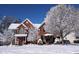 Beautiful two-story brick home surrounded by snow covered trees and a vibrant blue sky at 1004 Taywood Way, Apex, NC 27502