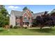 A charming brick home featuring a well-maintained lawn and lovely landscaping at 1004 Taywood Way, Apex, NC 27502