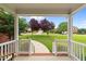 Inviting covered front porch with white railing, pillars, and a view of the manicured front yard at 1004 Taywood Way, Apex, NC 27502