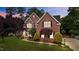 Charming brick home with manicured lawn, lush landscaping, and a welcoming walkway at 1004 Taywood Way, Apex, NC 27502