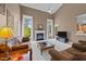Inviting living room featuring a fireplace, plush leather furniture, and ample natural light from large windows at 1004 Taywood Way, Apex, NC 27502