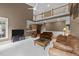 Open-concept living room showcases a fireplace, plush leather furniture, and ample natural light from large windows at 1004 Taywood Way, Apex, NC 27502