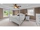 Inviting primary bedroom featuring a four-poster bed, carpet, and windows at 1004 Taywood Way, Apex, NC 27502
