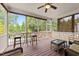 Relaxing screened porch features wood flooring, wicker furniture, ceiling fan, and backyard view at 1004 Taywood Way, Apex, NC 27502