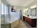 Primary bathroom featuring double vanity, soaking tub with glass shower, and wood look flooring at 1039 Bellenden Dr, Durham, NC 27713