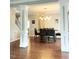 Open-concept dining room with hardwood floors, decorative columns, and modern chandelier lighting at 1039 Bellenden Dr, Durham, NC 27713