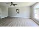 Bright living room featuring light-colored wood flooring, ceiling fan, and large arched window at 1039 Bellenden Dr, Durham, NC 27713