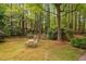 Secluded backyard with mature trees, lush greenery, and an inviting outdoor seating area at 108 Farren Ct, Cary, NC 27511