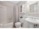 Clean, tiled bathroom featuring a shower/tub combo and pedestal sink with decorative mirror at 108 Farren Ct, Cary, NC 27511