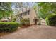 Side view of a tan two-story home with a detached garage and a beautifully landscaped yard at 108 Farren Ct, Cary, NC 27511