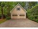 A two-car garage with a painted door and a traditional window is nestled in a lush green setting at 108 Farren Ct, Cary, NC 27511