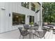 Inviting back porch with a seating area, black metal table and four chairs with natural light and views at 10817 Brass Kettle Rd, Raleigh, NC 27614