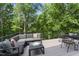 This cozy back porch features a gray sofa, black coffee table, and seating for relaxation and enjoyment of nature at 10817 Brass Kettle Rd, Raleigh, NC 27614
