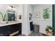 Stylish bathroom with a black vanity, marble countertop, decorative tiles, and ample natural light at 10817 Brass Kettle Rd, Raleigh, NC 27614