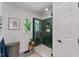 Modern bathroom showcasing a glass-enclosed shower with green tile and patterned floor tiles at 10817 Brass Kettle Rd, Raleigh, NC 27614