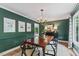 Elegant dining room with dark green walls and stylish lighting at 10817 Brass Kettle Rd, Raleigh, NC 27614
