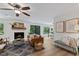Cozy living room featuring hardwood floors, a fireplace, stylish furniture, and access to the backyard at 10817 Brass Kettle Rd, Raleigh, NC 27614