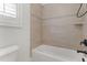 Bright bathroom features a white tub with neutral tile and a shower at 1101 Temple St, Raleigh, NC 27609