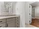 Bathroom with gray vanity and open door to closet with shelving at 1101 Temple St, Raleigh, NC 27609