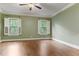 Spacious bedroom with two windows, ceiling fan and hardwood floors at 1101 Temple St, Raleigh, NC 27609