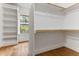 Bright walk-in closet with custom shelving and hardwood floors near window at 1101 Temple St, Raleigh, NC 27609