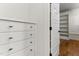 White dresser in walk-in closet; door open revealing shelves and hardwood floor at 1101 Temple St, Raleigh, NC 27609