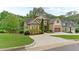 Exterior shot from the side angle of this home showcasing the driveway, lawn and manicured bushes and trees at 1101 Temple St, Raleigh, NC 27609