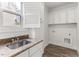 Laundry room featuring granite counters, wood-look flooring, and white cabinetry at 1101 Temple St, Raleigh, NC 27609