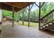 Spacious stamped concrete patio featuring structural columns and stairs to landscaped backyard at 1101 Temple St, Raleigh, NC 27609