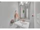 Powder room featuring a pedestal sink, decorative mirror, and neutral wall color at 1109 Agio Ct, Zebulon, NC 27597