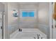 Luxurious bathtub with decorative tile surround and natural light at 1109 Agio Ct, Zebulon, NC 27597