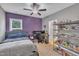A bedroom with a ceiling fan, purple accent wall, and shelving unit at 1109 Agio Ct, Zebulon, NC 27597