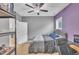Well lit bedroom with ceiling fan, purple accent wall and shelving unit at 1109 Agio Ct, Zebulon, NC 27597