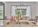 Dining table featuring updated lighting fixtures, neutral paint colors and view of outdoor wooded area at 1109 Agio Ct, Zebulon, NC 27597