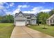 Charming gray two-story home featuring a well-manicured lawn and attached two-car garage at 1109 Agio Ct, Zebulon, NC 27597