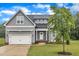 Beautiful gray home with a manicured lawn, attached garage, and inviting front porch at 1109 Agio Ct, Zebulon, NC 27597
