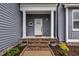 Inviting front porch with decorative accents and a charming white door on a gray home at 1109 Agio Ct, Zebulon, NC 27597