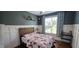Stylish bedroom with a dark accent wall, wood trim, and a window with patterned curtains at 1116 Trotter Bluffs Dr, Holly Springs, NC 27540