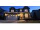 Inviting exterior elevation of home featuring stone accents, a covered porch, and an attached two-car garage at 1116 Trotter Bluffs Dr, Holly Springs, NC 27540