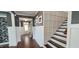 Foyer featuring dark hardwood floors, staircase, white wainscoting, and grey walls at 1116 Trotter Bluffs Dr, Holly Springs, NC 27540
