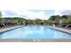 Large community pool with plenty of lounge chairs for relaxing by the water on a sunny day at 1116 Trotter Bluffs Dr, Holly Springs, NC 27540
