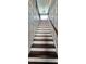 Staircase with wooden treads and white risers, framed by decorative white wall paneling at 1116 Trotter Bluffs Dr, Holly Springs, NC 27540