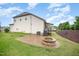 Backyard view of a two-story home with a paved patio and stone fire pit at 1201 Pleasant Falls Ct, Wake Forest, NC 27587