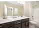 Bright bathroom featuring double sink vanity with large mirror and combined shower and tub at 1201 Pleasant Falls Ct, Wake Forest, NC 27587