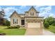 Charming two-story home with stone and siding details, lush lawn, and a two-car garage at 1201 Pleasant Falls Ct, Wake Forest, NC 27587