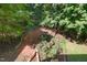 Aerial view of a brick patio in a lush backyard surrounded by mature trees at 122 N Fern Abbey Ln, Cary, NC 27518