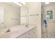 Bright bathroom features a double sink vanity, large mirror, and a shower with natural light at 122 N Fern Abbey Ln, Cary, NC 27518
