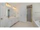 Bathroom with double sink vanity, shower, and white cabinetry for ample storage space at 122 N Fern Abbey Ln, Cary, NC 27518