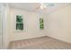 A cozy bedroom with neutral carpet, two windows offering natural light and a closet at 122 N Fern Abbey Ln, Cary, NC 27518