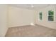 A bright bedroom offers a ceiling fan, neutral carpet, and natural light from two windows at 122 N Fern Abbey Ln, Cary, NC 27518